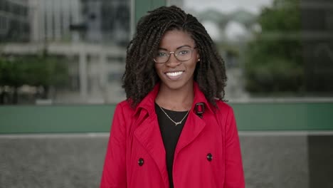 Afroamerikanische-Frau-Blickt-In-Die-Kamera,-Lächelt-Und-Korrigiert-Die-Haare
